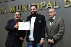Valmir Mendonça (e) recebe o diploma entregue pelo vereador Rodrigo Maroni (c)