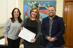 Mônica Leal (c) recebeu das mãos da coordenadora do GISA o documento para realização do convênio