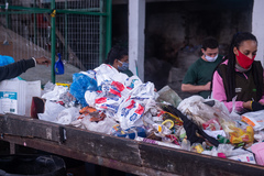 Trabalhadores fazem separação do material na esteira de reciclagem da Coopertuca