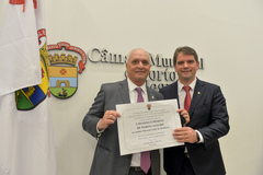 Marcelo Medeiros (e) recebe o título entregue por Márcio Bins Ely (PDT)
