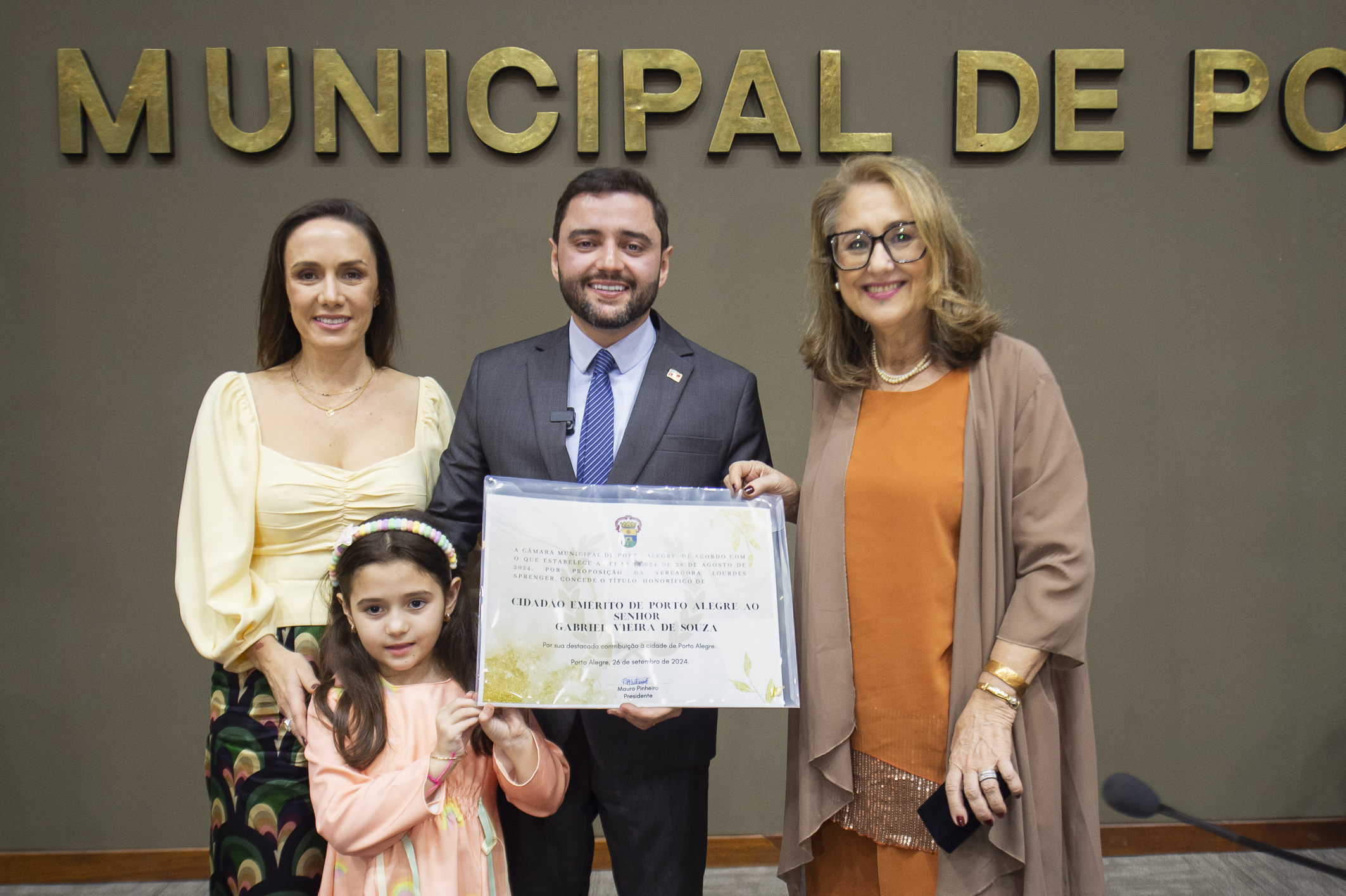 O homenageado Gabriel Souza, ao lado da esposa e da filha; e a proponente, vereadora Lourdes Sprenger 