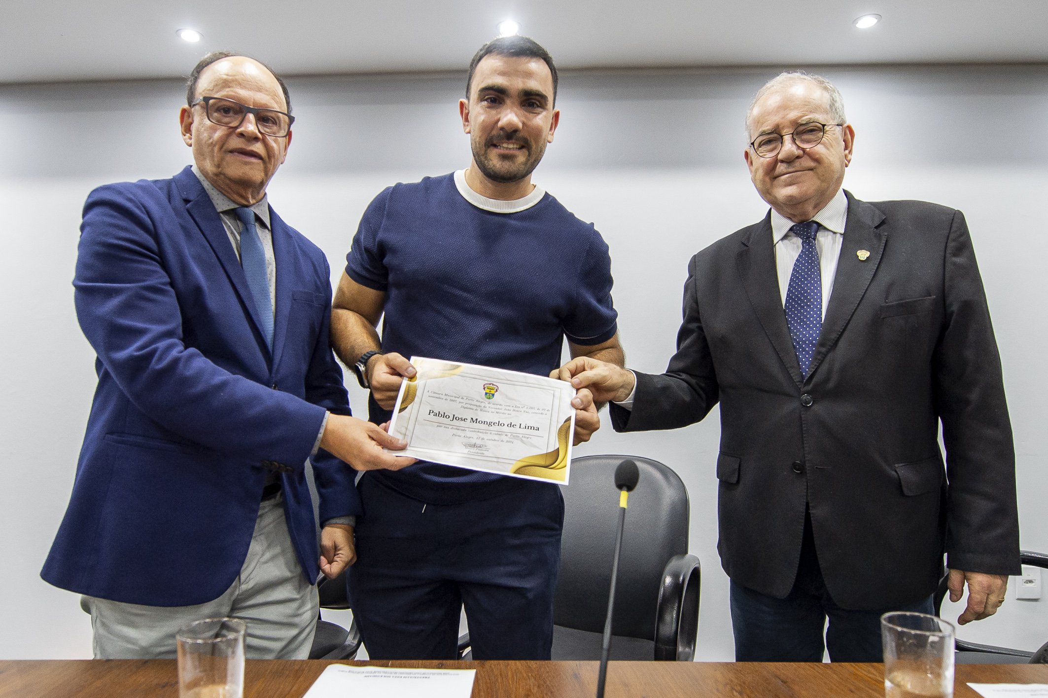 O proponente, vereador João Bosco Vaz; o homenageado, Pablo Mongelo de Lima; e o presidente da sessão, vereador Idenir Cecchim